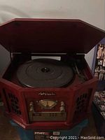 Front view of the Anders Nicholson wooden record player with hexagonal front and gold controls