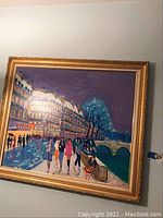 Full front view of the framed painting showing Paris street scene along a river with figures walking