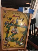 Full view of vintage Poosh Mup Jr. 4-in-1 game showing colorful artwork and wooden frame.