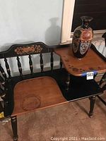 Full view of the vintage gossip bench with attached wooden table and decorative vase placed on the table.