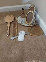 Photo of entire vanity set including tray, hand mirror, photo frame, comb, and handheld mirror showing overall set condition and layout.