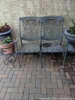 Front view of the cast aluminum loveseat showcasing lattice seat and the ornate backrest design