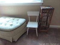 Photo showing a tufted cloth ottoman, white wooden child's chair, and wicker plant stand.