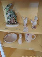 Lot displayed on shelf with Sadek parrot figurine, two dove figurines, and Franciscan servingware including bowl, mug, salt and pepper shakers