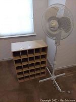Shoe cubby with 24 compartments next to Windmere floor fan.