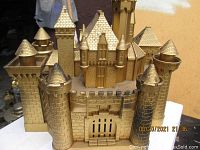 Large golden castle dollhouse exterior with turrets and battlements.