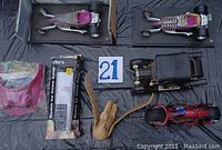 Photo showing two metal toy cars, wooden violin replica, wooden handled replica Colt gun and other assorted items