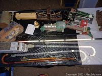 Photo showing canes, model trains, wooden whistle, tin mug, carved figurine, and wooden bookends