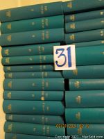 Blue-green hardbound volumes of The New Yorker magazine stacked on a shelf, showing the lot number 31 marker.
