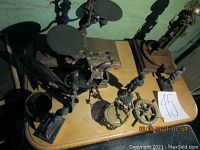 Group photo of brass and bronze decorative items including scales, clock parts, chair and figurines.