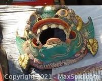 Close-up of colorful carved painted decorative mask with intricate detailing.