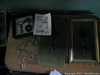 Keys including framed ornate keys, a book with mounted keys, and loose keys on surface