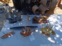 Overview of all seven ship and boat models including built clipper ships, sailboats, submarine, and metal sculptures