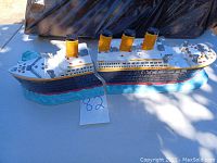Ceramic Titanic serving dish assembled showing full ship profile with four yellow smokestacks and black hull on blue water base.