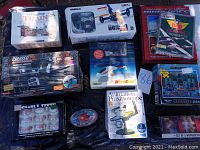 Group photo showing boxed toys including train model, UdiRC drone, Harley Davidson walkie talkies, model airplane kit, puzzle box, gnarly teeth, praxinoscope and more.