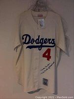 Full front view of jersey in protective sleeve showing team script, number and autograph