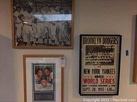 Wide photo showing three framed items on wall: two black and white photos and one Brooklyn Dodgers 1955 World Series poster.