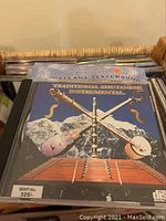 Music CD titled Traditional Bhutanese Instrumental showing musical instruments and mountains, located in basket with more DVDs and audio books.