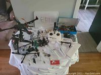 Wide view of the drone parts laid out together showing frame, controller, propellers, and small components.
