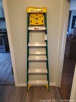 Front view of the Featherlite folding ladder showing the steps and the yellow tool tray at the top.