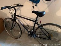 Side view of the black Giant Farrago men's bicycle showing frame, tires, saddle, handlebars, pedals, and gear system.