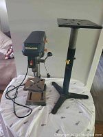 Full view of Mastercraft drill press and separate adjustable stand on a fabric covered surface.