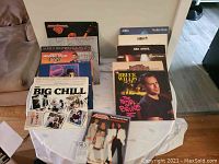 Overview of multiple vinyl records displayed on a white table showing various artists and soundtracks.