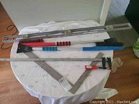 Photo showing the full set of tools on a round table covered with white cloth against a dark floor background.