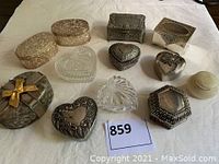 All 12 vintage silver and crystal jewelry and ring boxes showcased on white cloth, varying shapes including hearts, ovals, and rectangle with intricate patterns and clear crystal pieces.