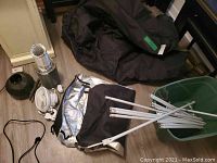 Wide shot showing grow tent bag, metal poles, white clip fan, ducting, and carbon filter fan.