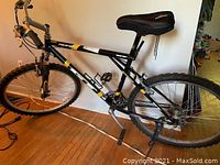 Full side view of bike showing frame, saddle, wheels, pedals, bottle cage and kickstand