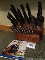 Wooden Cutco block filled with knives and box manual visible