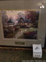 Full view of framed Thomas Kinkade 'Make A Wish Cottage' print with decorative plaque and gold carved frame.