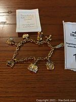 Charm bracelet displayed in full with certificate of authenticity on wooden surface.