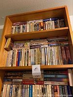 Photo showing wooden bookshelf with three shelves densely packed with books of various sizes and colors