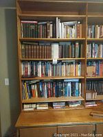 Full front view of multiple shelves filled with books of varying sizes and colors including religious and other texts