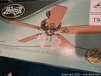 Box of the Hunter Augusta II ceiling fan showing fan and light fixture, bright brass finish, 5 blades, frosted glass light shades.