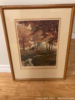 Full view of the framed artwork showing a wooded landscape with a stream.