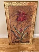Front view of the framed wall art painting showing a red flower with green leaves on a brown background and detailed gold frame.
