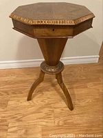 Front view of the octagonal sewing table on pedestal base