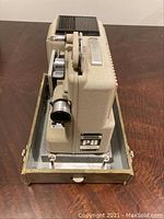 Angle view showing the textured beige metal body, ventilation slots, lens and Eumig P8 badge on side.