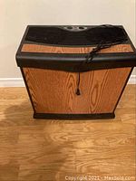 Full front view of humidifier showing woodgrain panel and power cord coiled on top