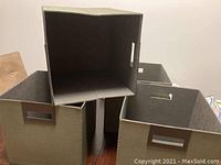 Four gray fabric storage bins with rectangular shapes and handle cutouts, positioned for display.