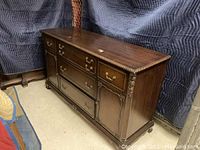 Photo showing full front view of the vintage wooden buffet with storage drawers and cabinets