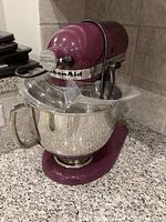 Front-quarter view of mixer on countertop showing head, bowl, pouring shield and cord