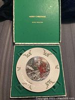 Photo of the Royal Doulton Christmas plate in the original green box with gold text