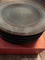 Stacked view of 8 dinner plates showing textured concentric circles in blue shades.