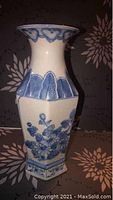 Photo shows blue and white hexagonal vase with floral decorations.
