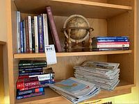 Photo of shelves showing books about travel, gemstones, wine, Alzheimer's, and a wooden globe.