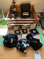 Overhead view showing wooden crate with wooden box, figurine, coins, binoculars, geodes and rocks laid out on table
